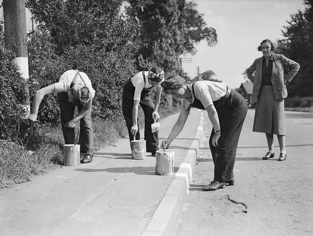 #53 Women Road Painters, 1941. Women doing men’s jobs, painting the kerb white so it can be seen during the blackout in World War Two.