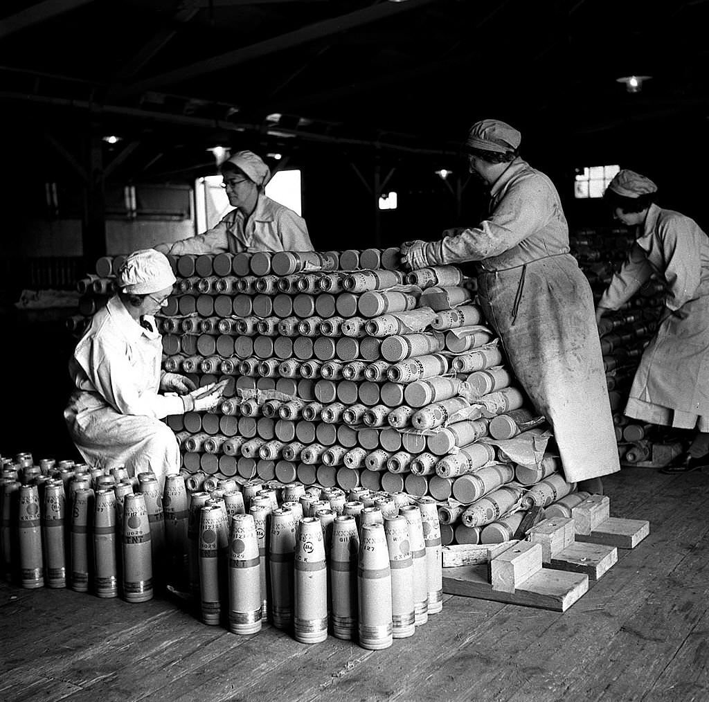 #78 Women workers stack ammunition shells at a factory in Woolwich, London, 1940