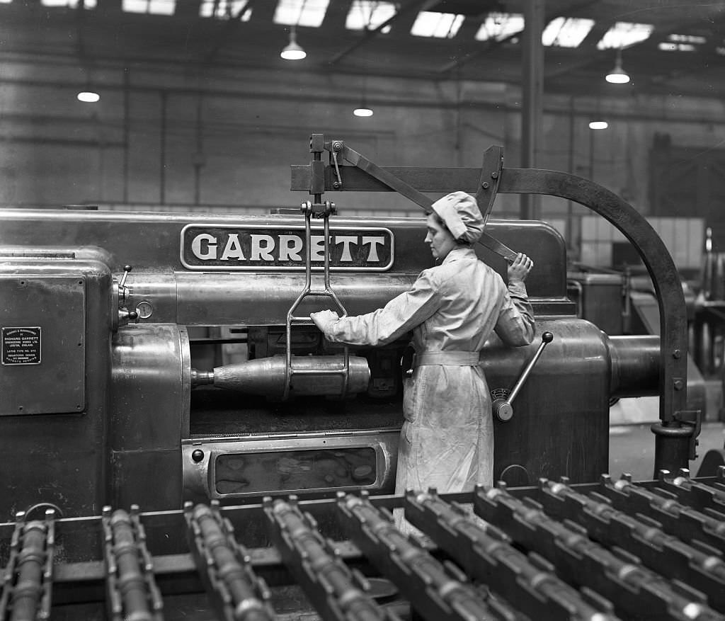 #87 female employee loading a 6in. shell onto the finish turning machine
