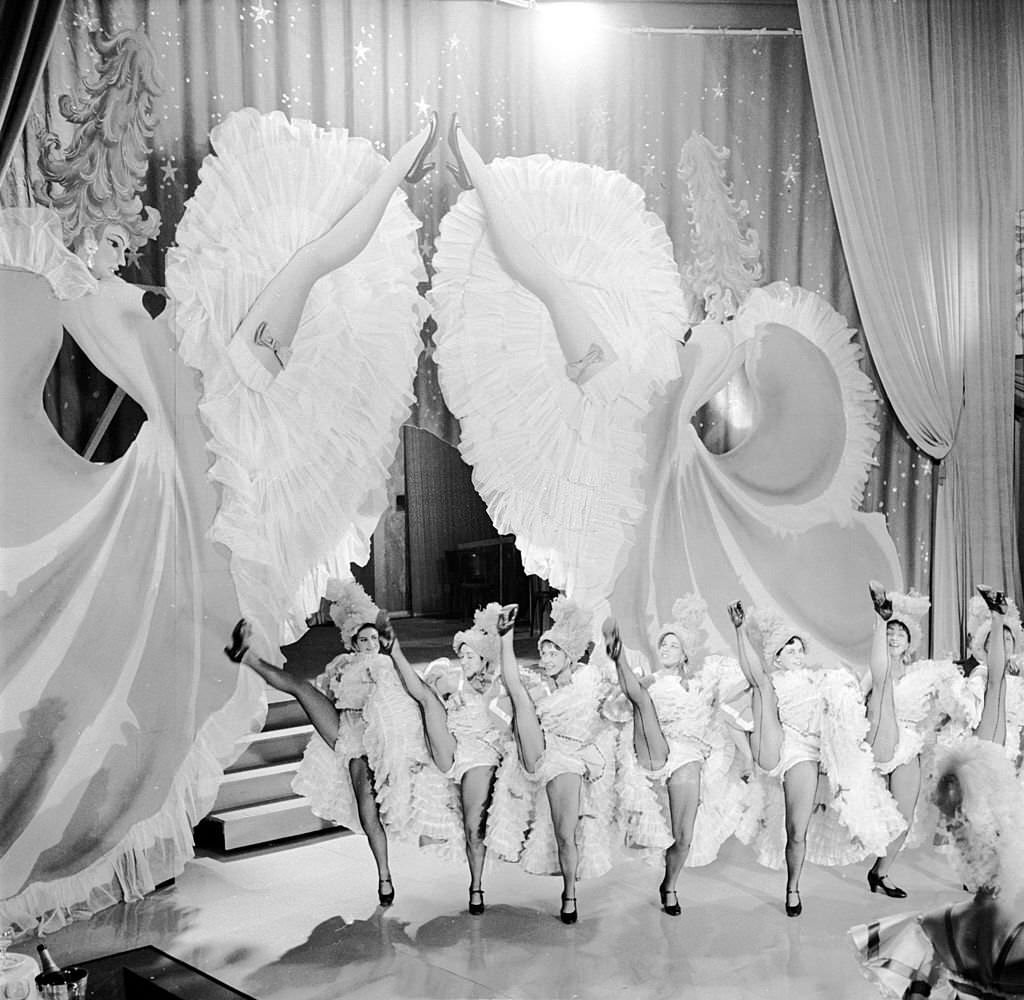 #48 Dancers from Miss May’s troupe perform French Cancan on a barge during the river festival at Bassin de la Villette, 1955