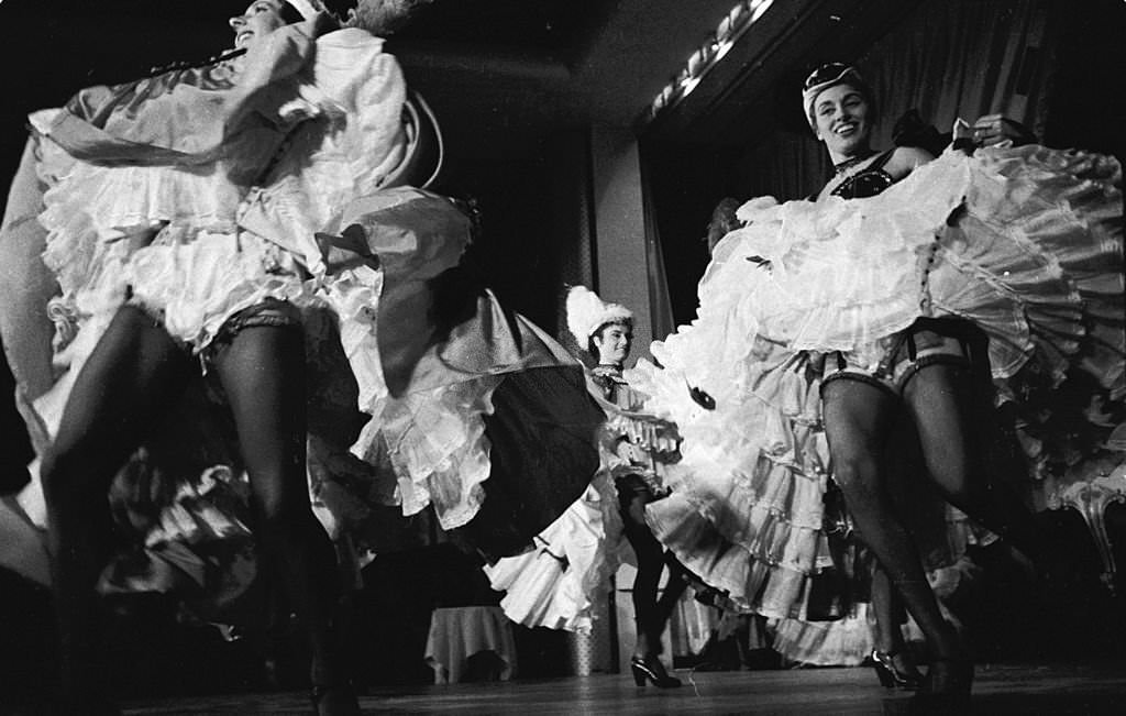 #53 Can-Can girl Regine performing with the rest of the troupe at the Moulin Rouge in Paris, 1955.