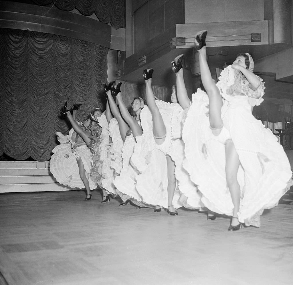 #69 A chorus of high-kicking Cancan dancers go through their paces in preparation for the reopening, of the Parisian Music Hall Tabarin.
