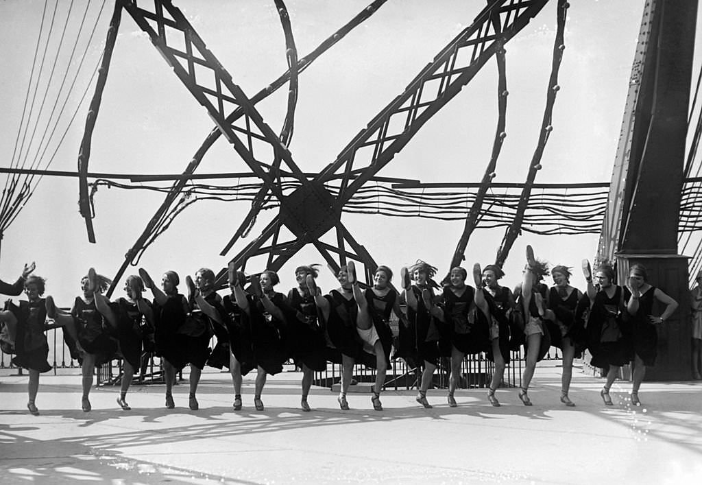 #92 Dancers of famous cabaret ‘Moulin Rouge’ at the Eiffel Tower in September 1929 in Paris, France.