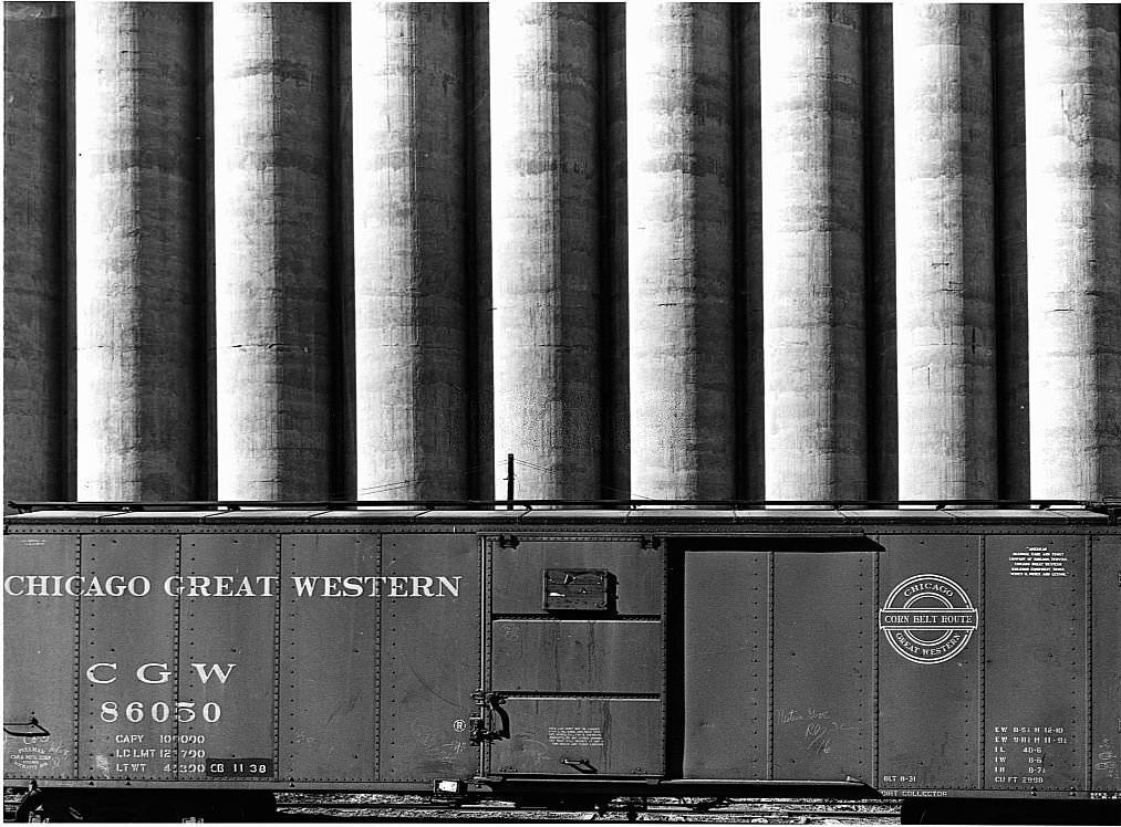 #7 Chicago Great Western freight cars beside a giant grain elevator.
