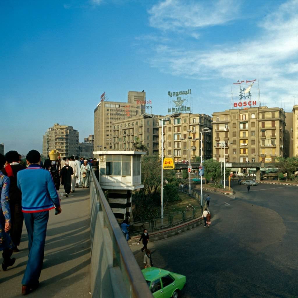 #99 Passers by crossing a pavement bridge at Midan al Tahrir square, Cairo, Egypt, late 1970s.