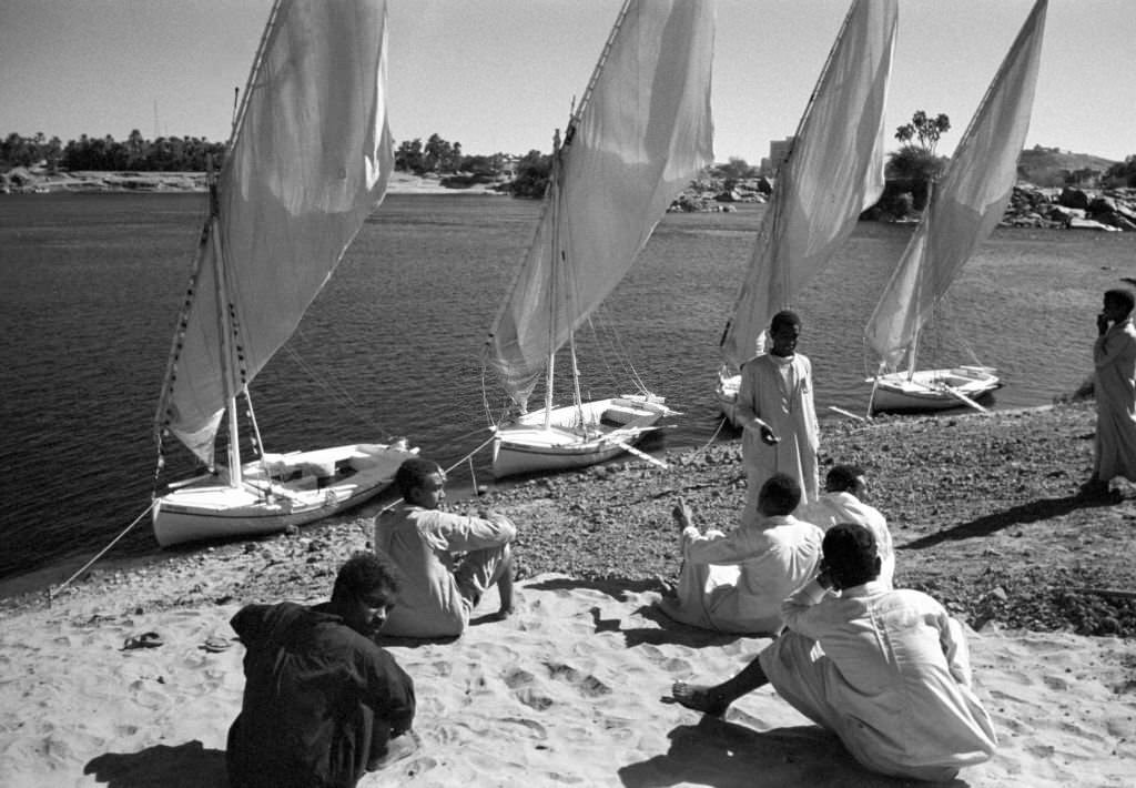 #50 Men sit on the banks of the Nile near Aswan (Egypt) in front of small boats, so-called feluccas, 1972