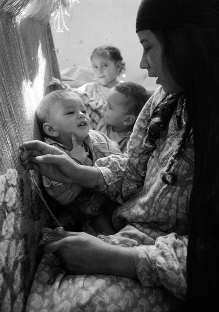 #54 A carpet weaver with her children at work in a village near Cairo, 1972