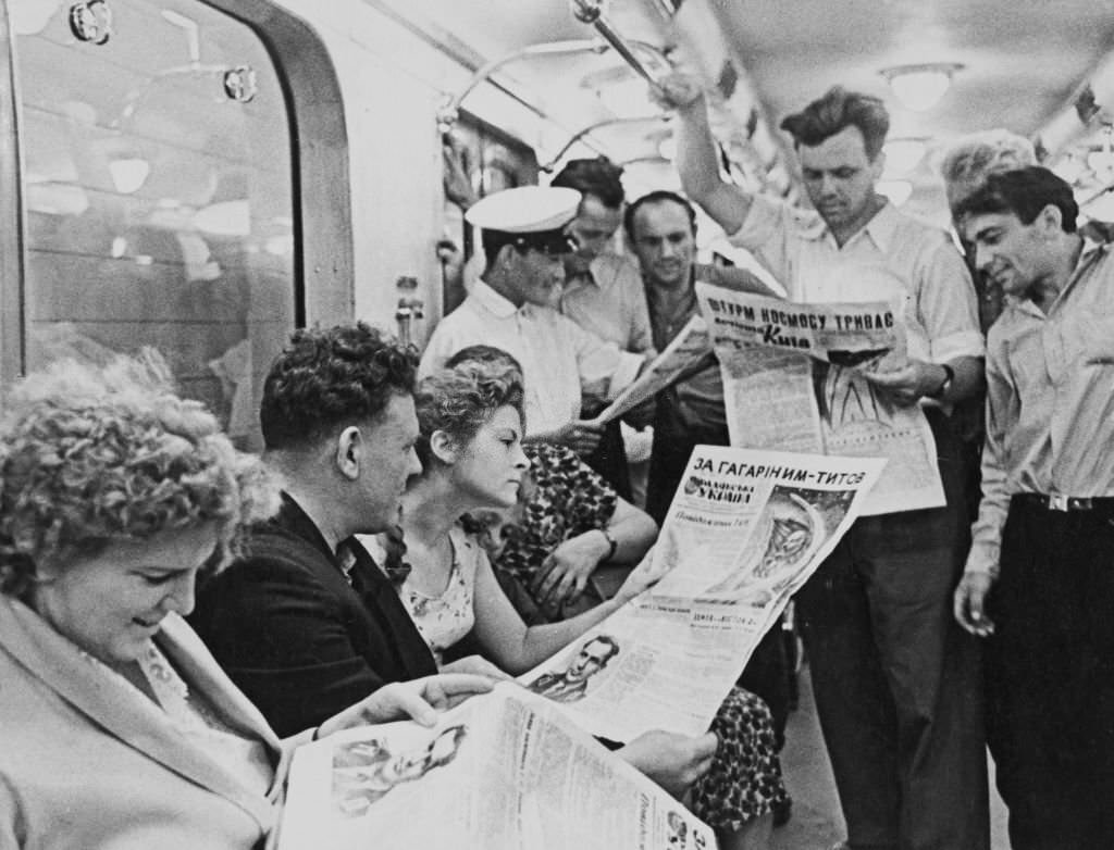 #59 Commuters in a carriage, some reading newspapers reports about Soviet cosmonaut Gherman Titov (1935-2000) who had become only the second human to orbit the Earth, 1960