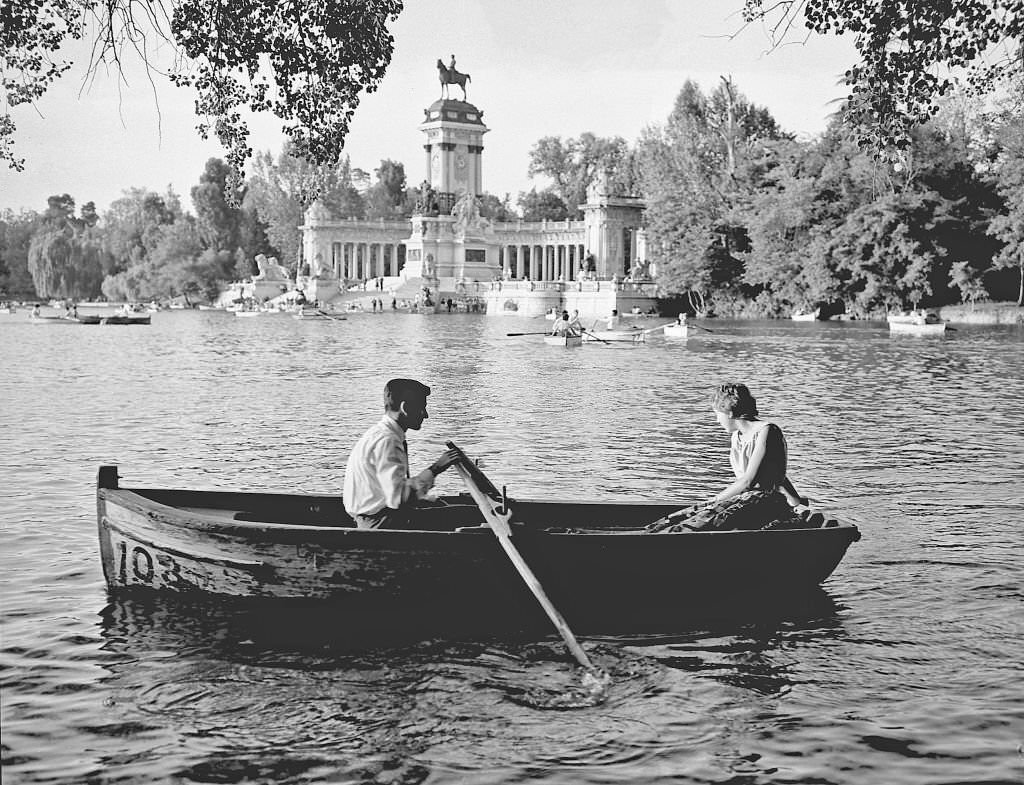 #91 A couple row in a boat on the Retiro pond during the 1960s in Madrid, Spain.