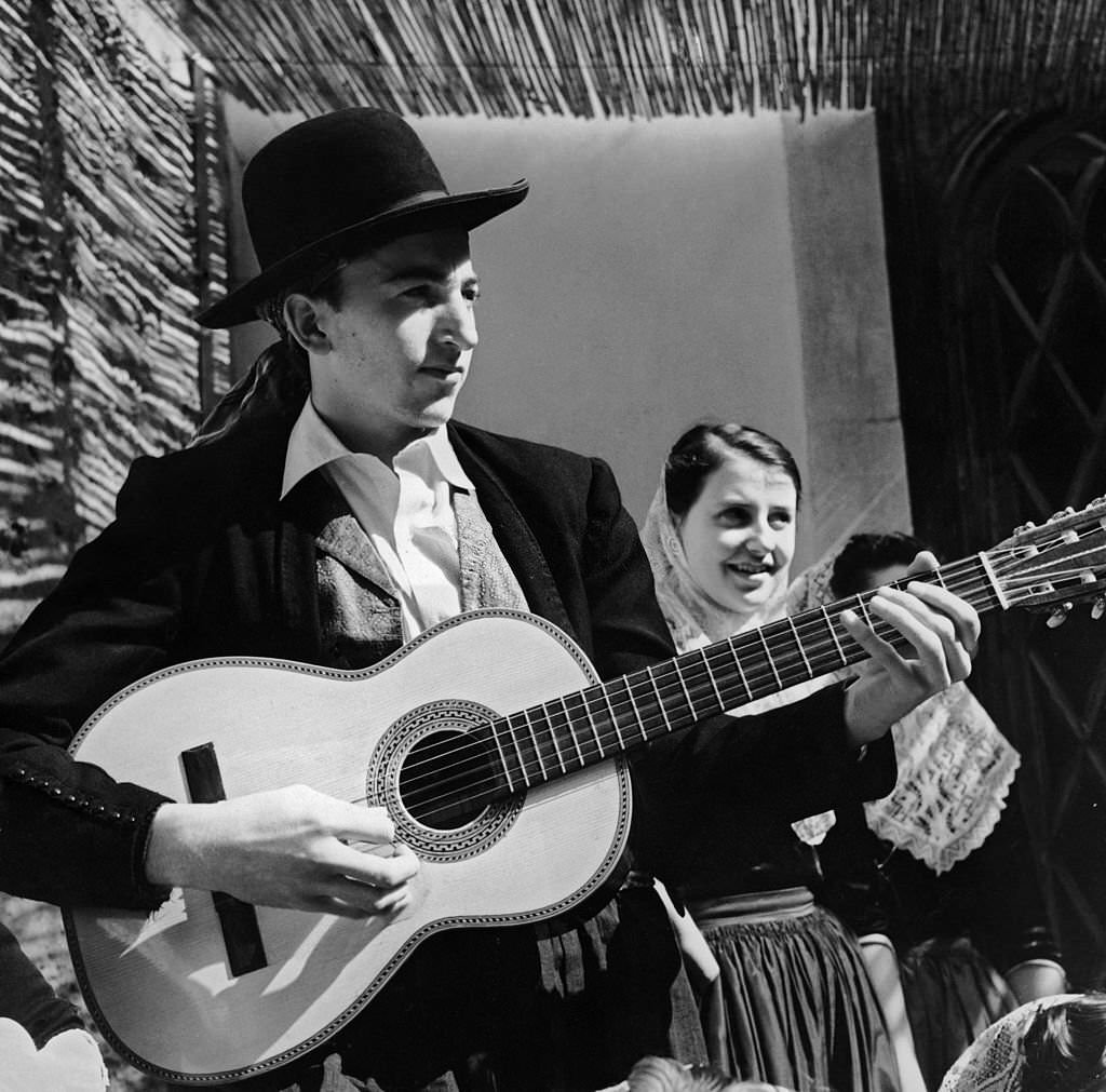 #107 A Spanish guitarist and two young women in folk costumes from the Balearic island of Majorca, 1955.