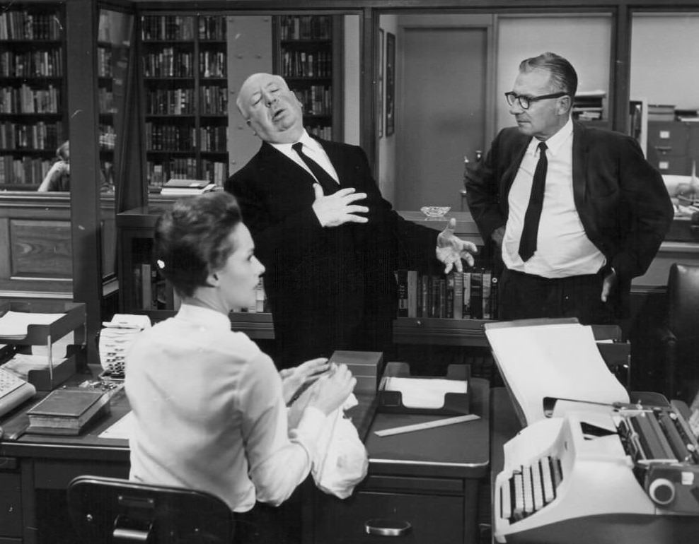 Director Alfred Hitchcock demonstrating a scene to actress Tippi Hedren as cameraman Bob Burk watches, on the set of the movie ‘Marnie’, 1964.