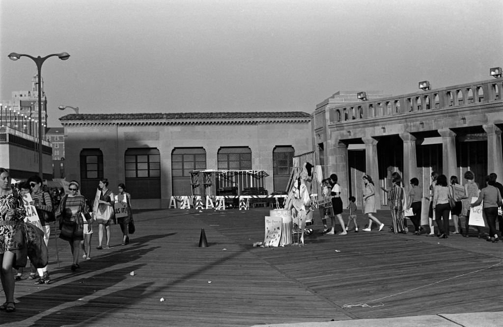 #19 On the Atlantic City Boardwalk, demonstrators, many with posters, protest the Miss America beauty pageant, Atlantic City, 1968.