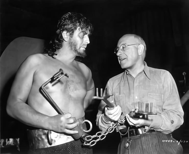 Victor Mature and Cecil B DeMille pose with Prop Ancient Keys on set candid during filming of ‘Samson and Delilah’, 1949