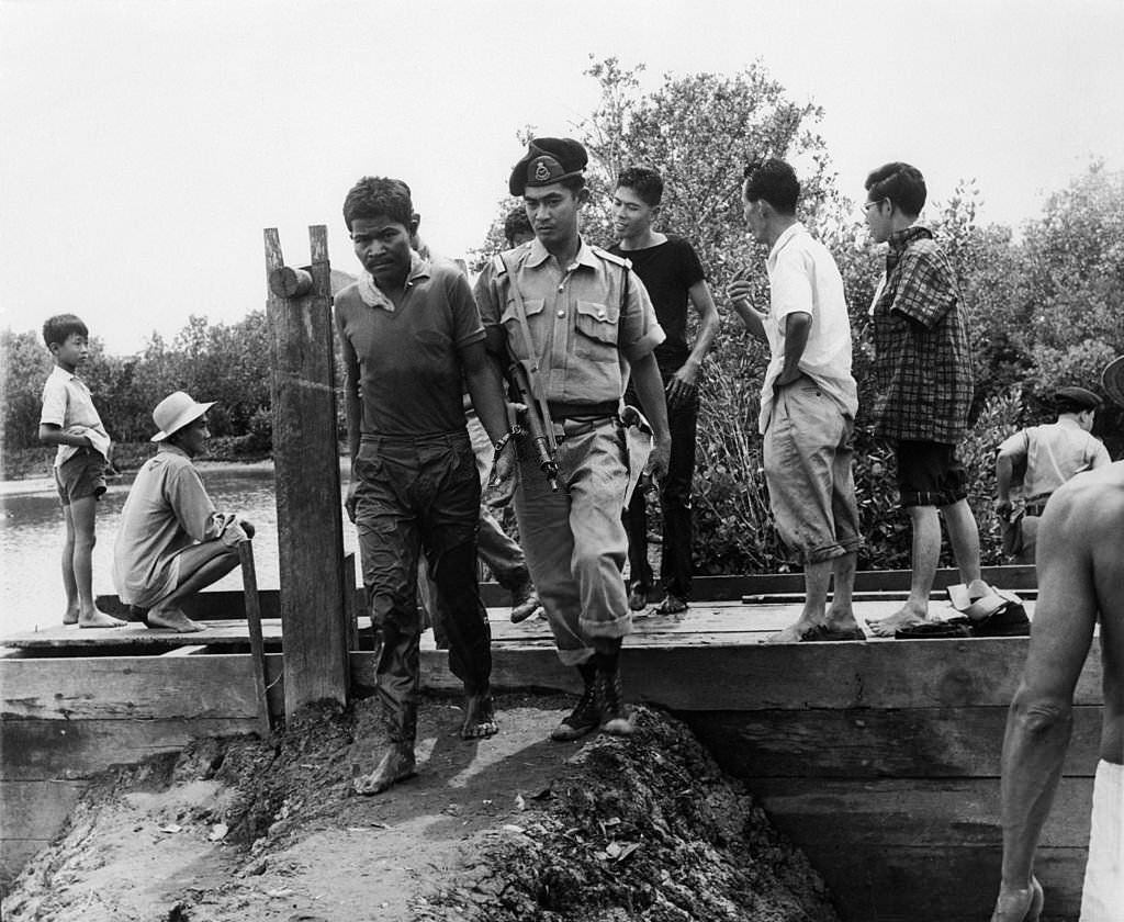 #18 A group of Indonesians being led away for interrogation by the police after their capture on Singapore Island, 1964