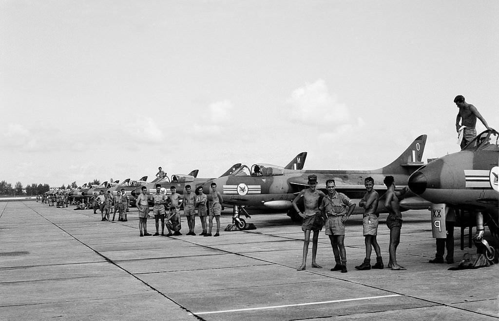 #52 RAF Number 20 Squadron with 12 Hunter Mk 9 fighter jet aircraft pictured at their base with ground crew personal by each plane, Singapore, 1962