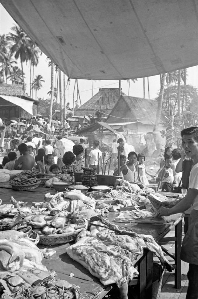 #67 Man cutting the meat displayed on his stall, Singapore, 1962