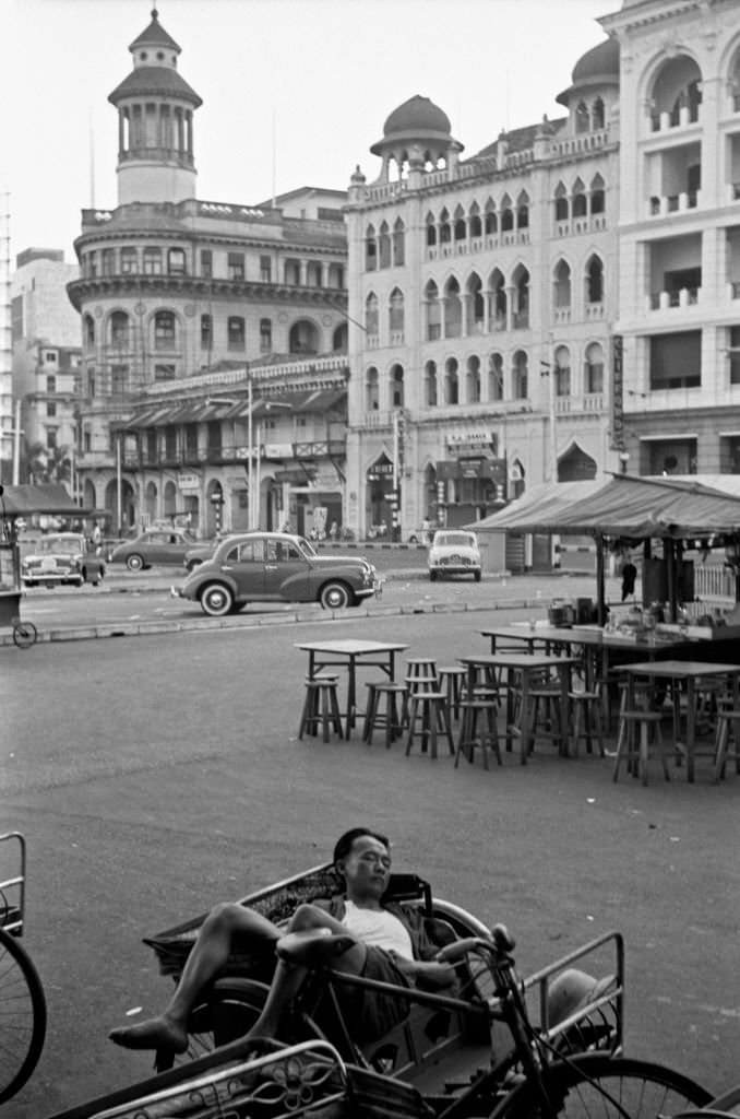 #92 Asian man sleeping lying into his rickshaw, Singapore, 1962