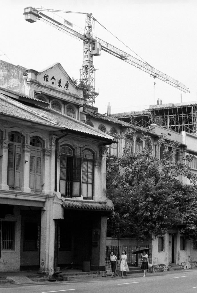 #49 A crane aids construction of Chinatown Plaza on the corner of Neil Rd and Craig Rd, while authentic shophouses on Neil Rd await a conservation order Chinatown, Singapore, 1983