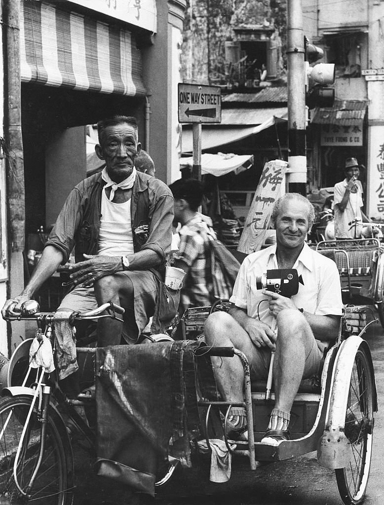 #78 Tourist with a film camera in a cycle rickshaw in Singapore, 1980s