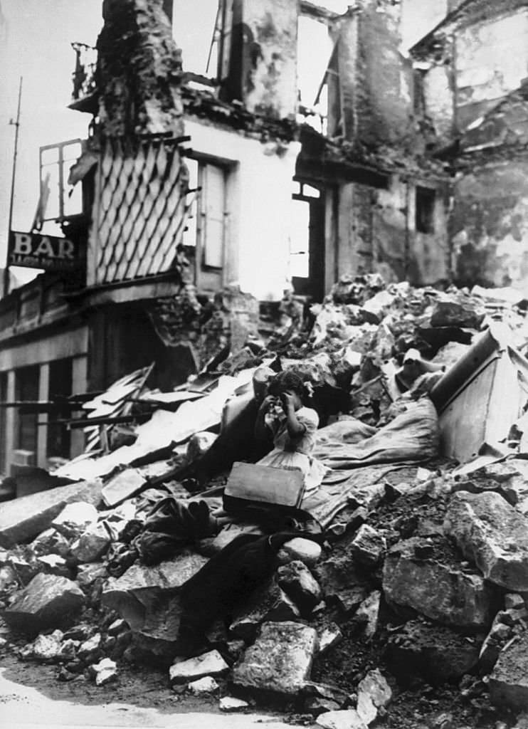 #104 During the Spanish civil war, a young girl is crying and sitting in front of the ruins of her house in Irun.