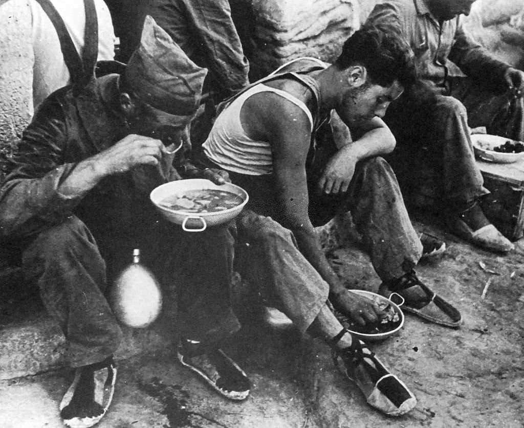 #162 Republican soldiers rest for food, during the Spanish Civil War.