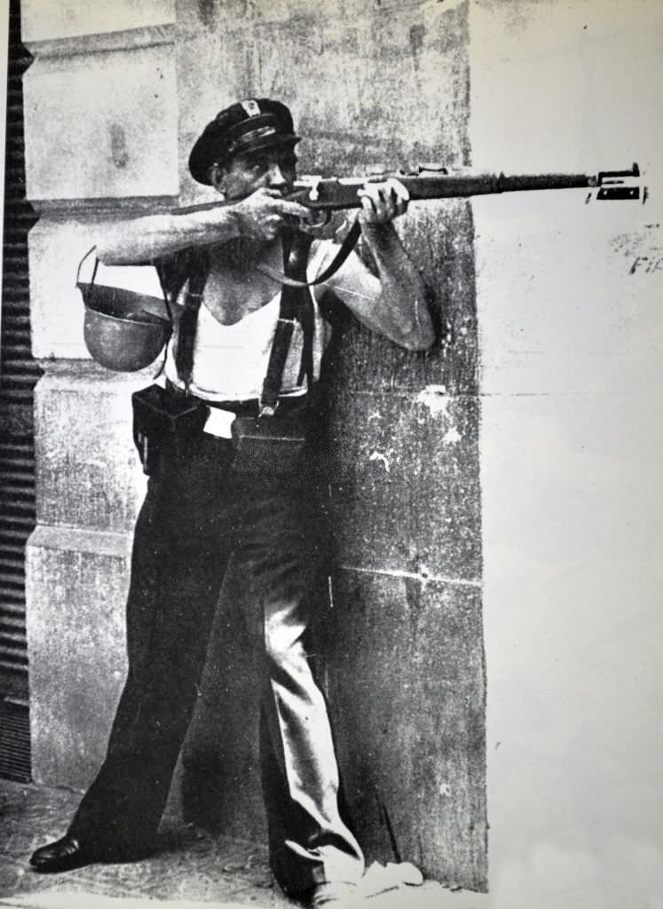 #22 A republican marksman soldier takes shelter behind a street corner during the Spanish civil war, Barcelona 1936.