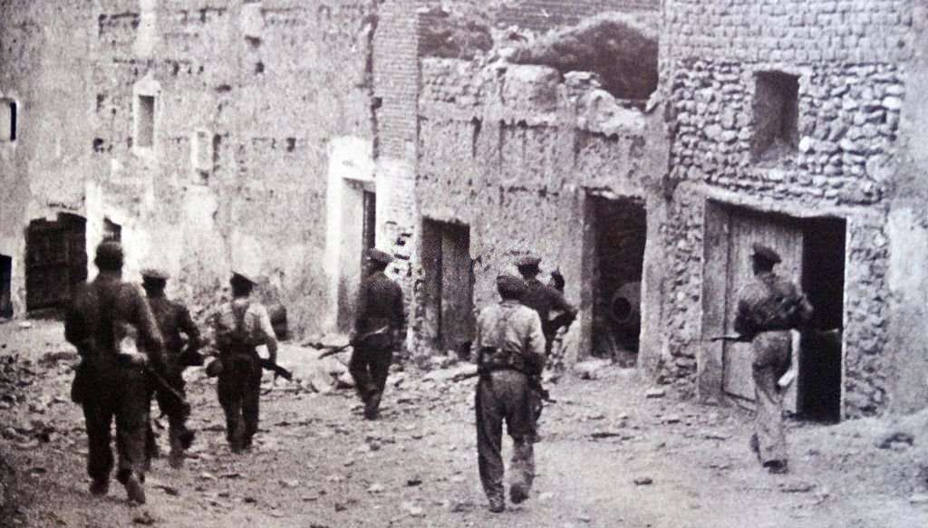 #37 Republican soldiers enter the deserted ruined town of Lleida (Lerida) a key defense point for Barcelona during the Spanish Civil War.