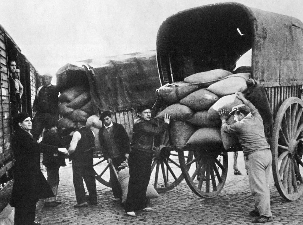 #67 Grain supplies are transferred from carts to rail trucks for distribution during the Spanish Civil War 1936.
