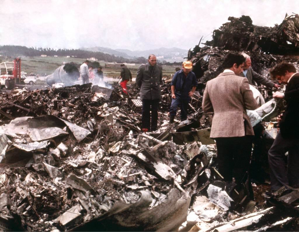 #1 Emergency workers sift through the wreckage of the two Boeing 747s which collided on the runway, killing 583 people