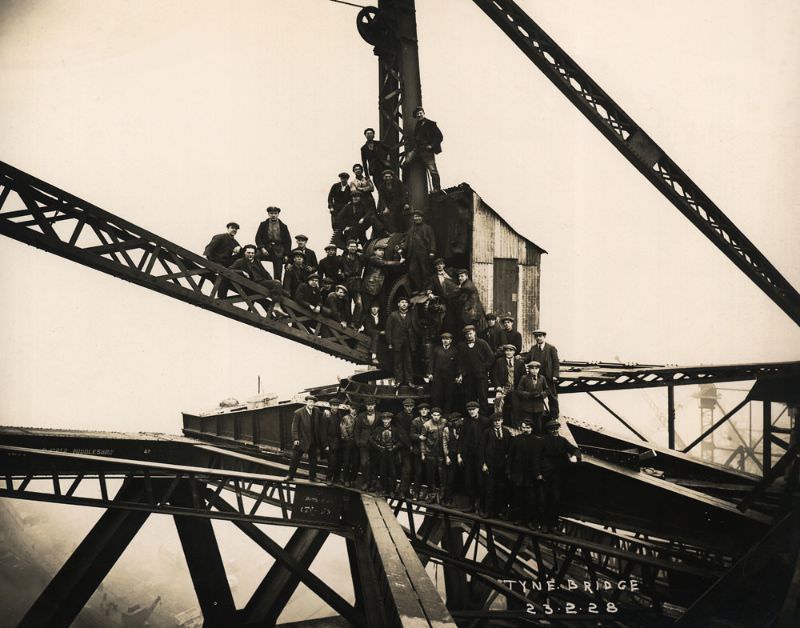 #24 Steel erectors, riveters and crane drivers perch on a 20-ton capacity crane to mark the completion of the Tyne Bridge arch, February 23, 1928