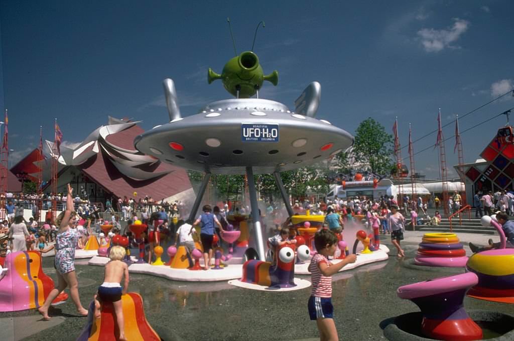 #175 Children play on brightly colored playground equipment that sprays water at the 1986 World’s Fair in Vancouver.