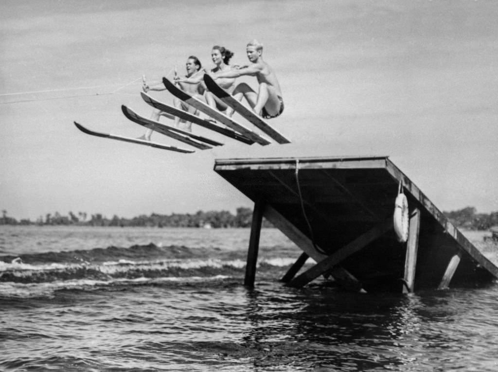 #115 Trammel Pickett, Martha Mitchell and Dickie Rowe go up and over the high jum while tuning up the tournament, in the 1930s