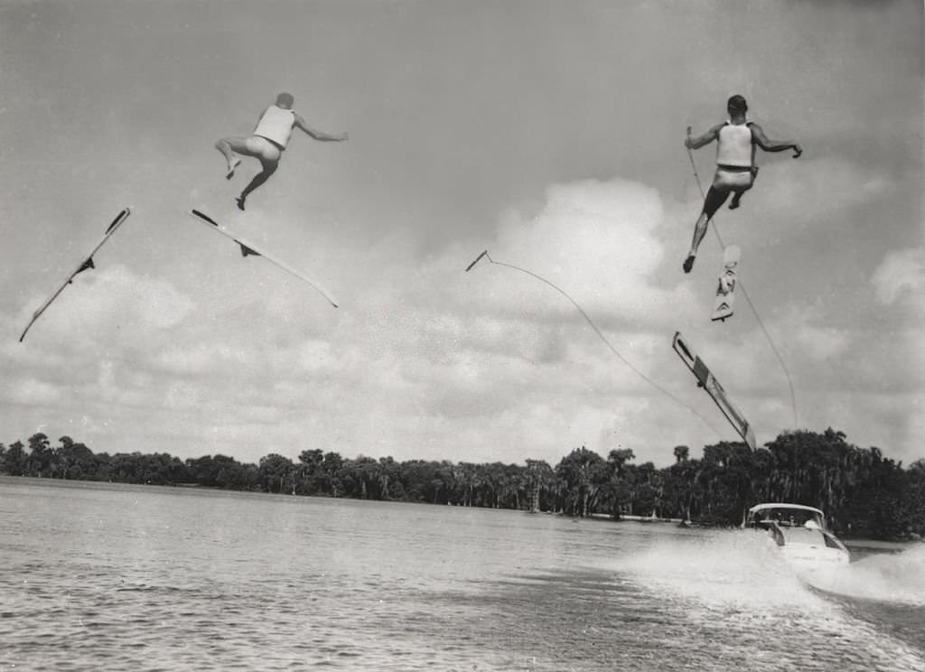#144 Two professional water-skiers lose their skis, and flounder helplessly in mid-air, during a competition at Cypress Gardens, Florida, 1965