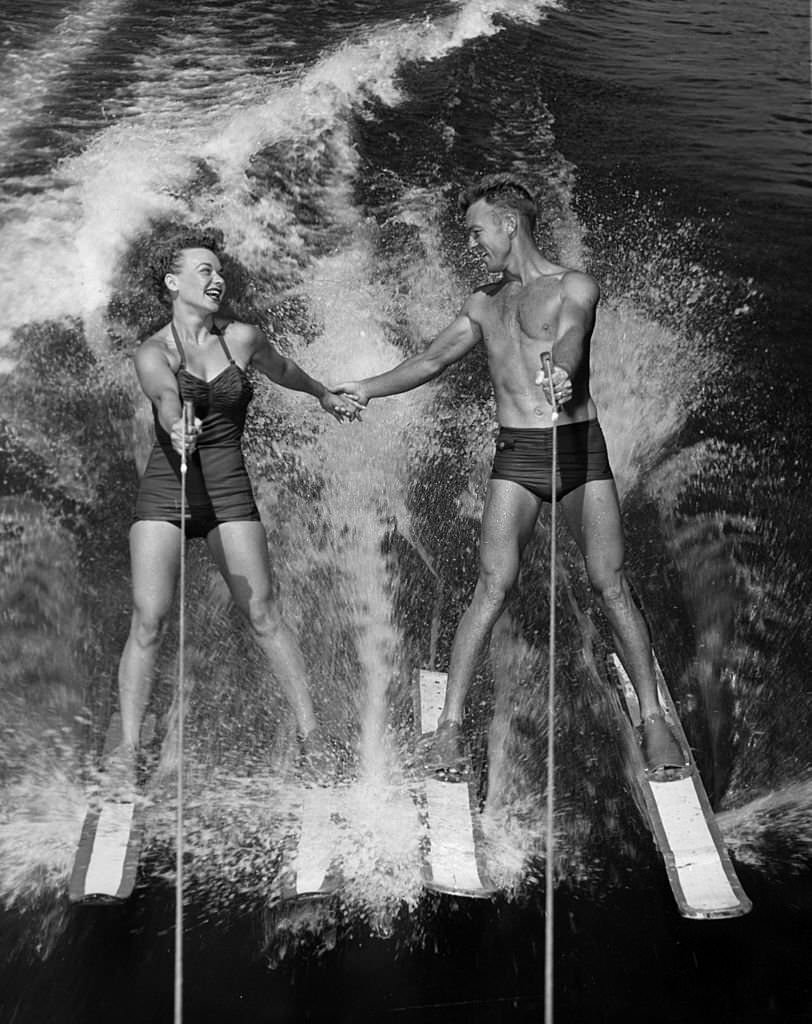 #153 Water-ski champions Dick Pope and Jean Mason prepare to transfer from four skis to one as they speed across the course at the US Ski Centre at Cypress Gardens, 1963.