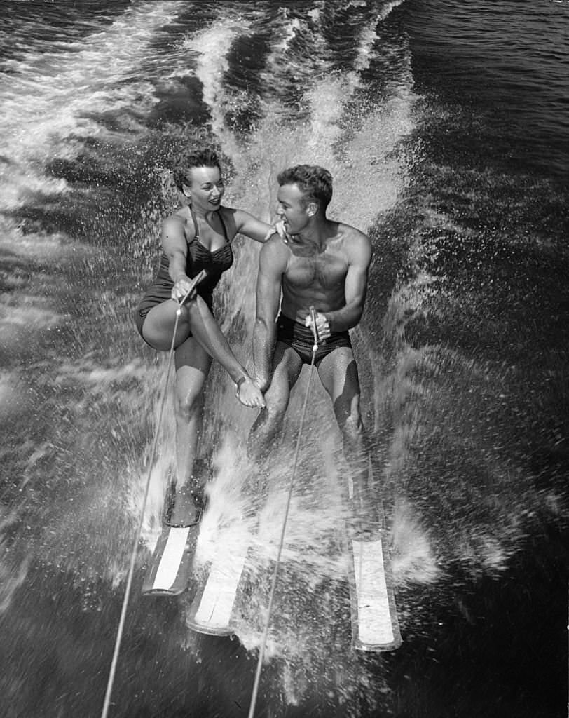 #154 Water-ski champions Dick Pope and Jean Mason prepare to transfer from four skis to one as they speed across the course at the US Ski Centre at Cypress Gardens, 1963