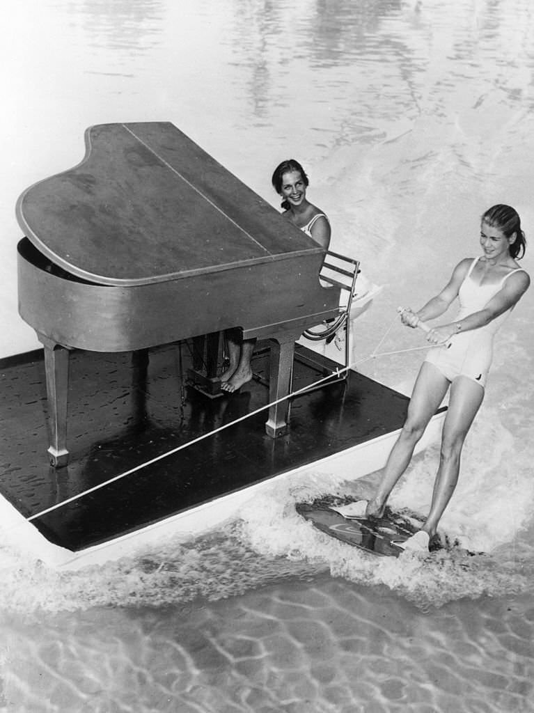 #157 A floating piano and pianist accompany a water-skier on Lake Eloise at Cypress Gardens in Florida, 1962