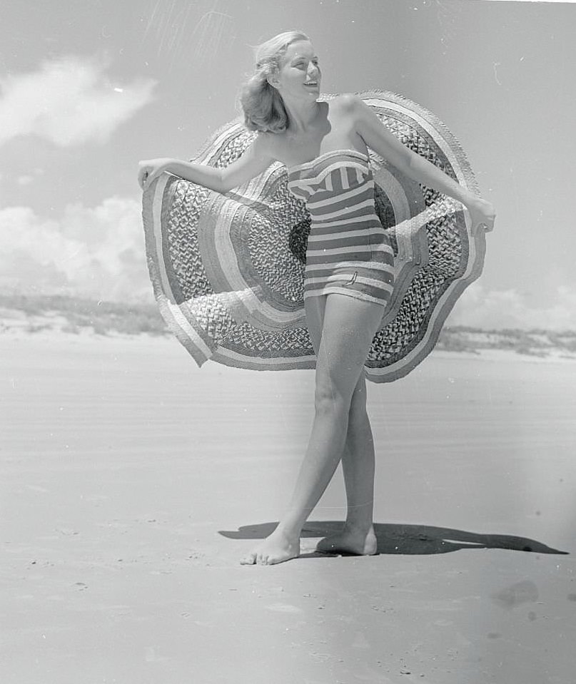 #36 Pretty Ann Stolz, Cypress Gardens Aquamaid, takes off her wide brimmed sombrero to enjoy the sun at Daytona Beach.