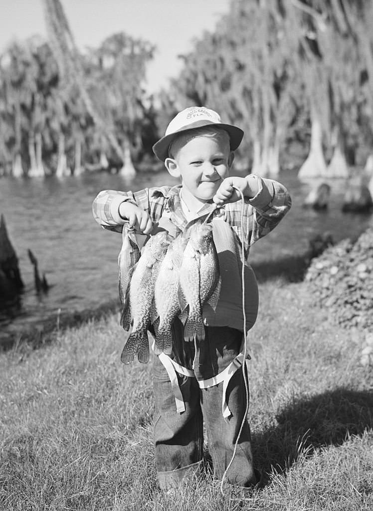 #40 Little Terry Paulin seems to have more than his share of angler’s luck. He caught this string of bass in Lake Eloise at Cypress Gardens and is all set for a fish fry.