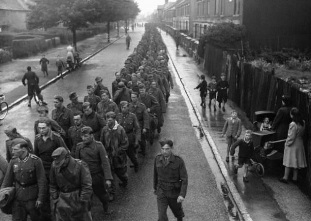 #9 A steady stream of German prisoners is pouring into this country from the battle of Normandy. German prisoners, captured on the beaches of Normandy, march through a street, somewhere in England, on June 9, 1944