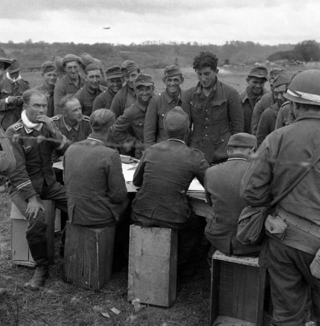 #30 German soldiers, captured by Allied Armies on the Normandy beachheads in France on June 16, 1944, are checked by fellow prisoners.