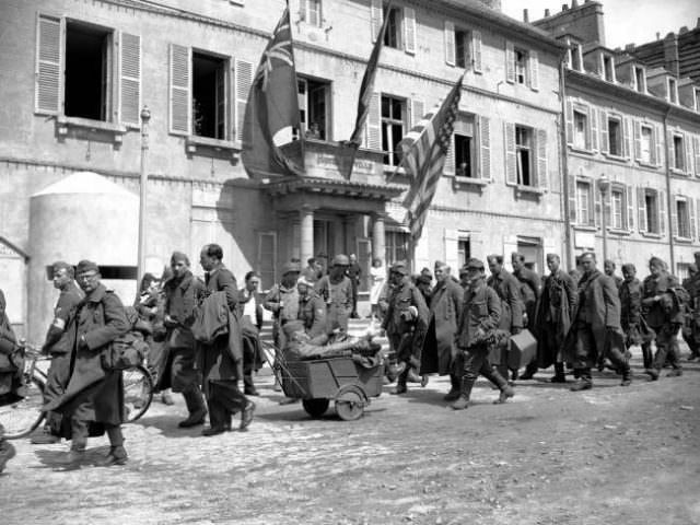 #39 German prisoners file past the Town Hall at Cherbourg on their way to a stockade on June 28, 1944.