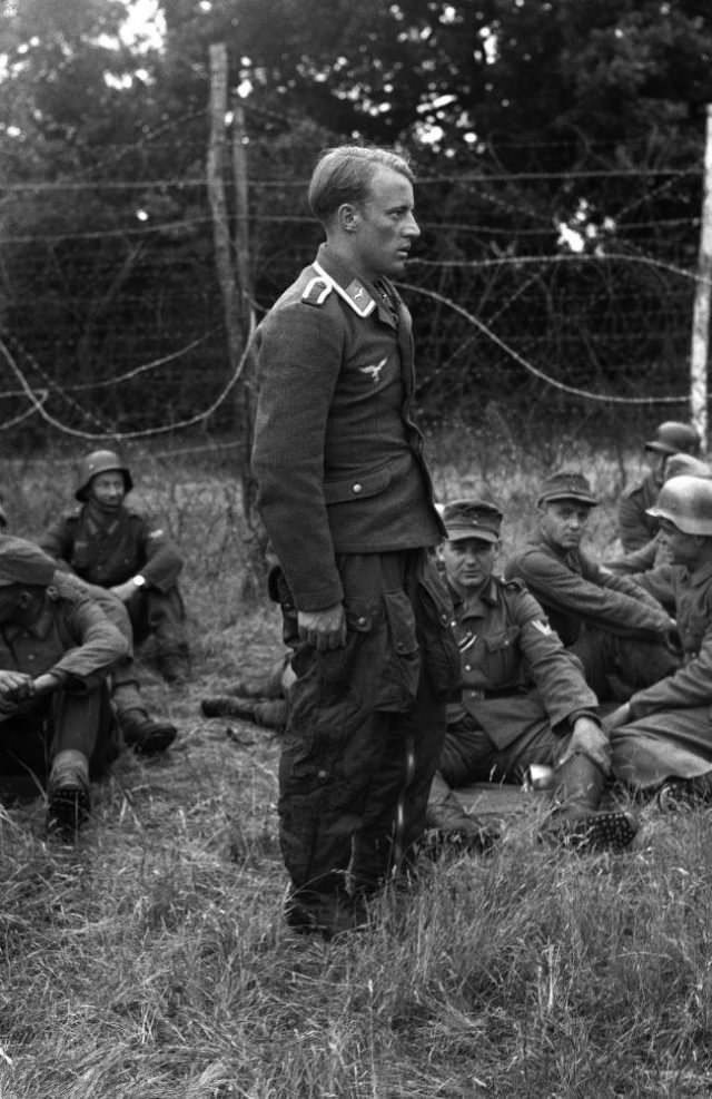 #8 The first Nazi airman to be shot down in the invasion area stands dejected amongst other prisoners at a camp somewhere in England, on June 9, 1944.
