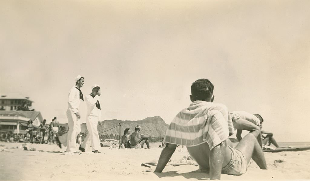 #91 Two sailors walk in uniform on beach. Diamondhead in background, 1940s