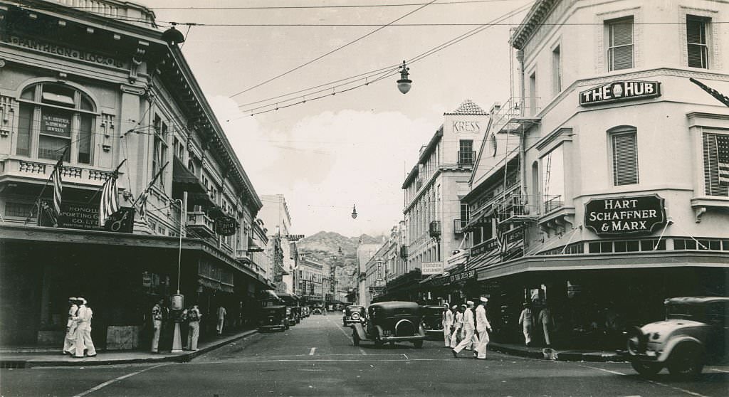 #99 Broad commercial street with cars and sailors, 1940s