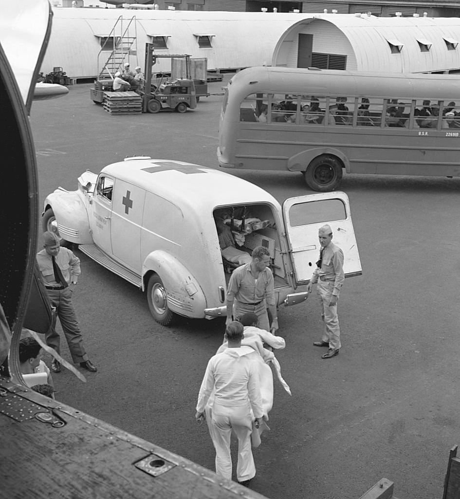 #106 A wounded POW is unloaded from a transport plane to a Red Cross ambulance in Honolulu. October 1945.