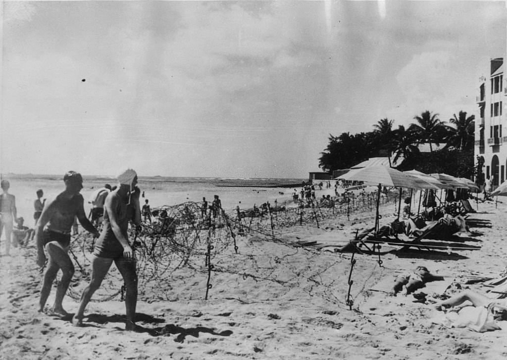 #108 The beach of the Royal Hawaiian Hotel in Honolulu which has been leased by the American navy for officers and men on leave. The barbed wire on the beach does not stop them enjoying a swim, 1940s