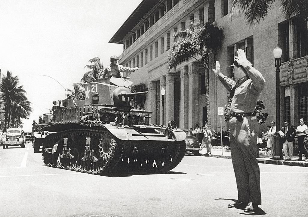 #109 In Honolulu a policeman runs traffic to allow the passage of a line of tanks. Honolulu, March 1942