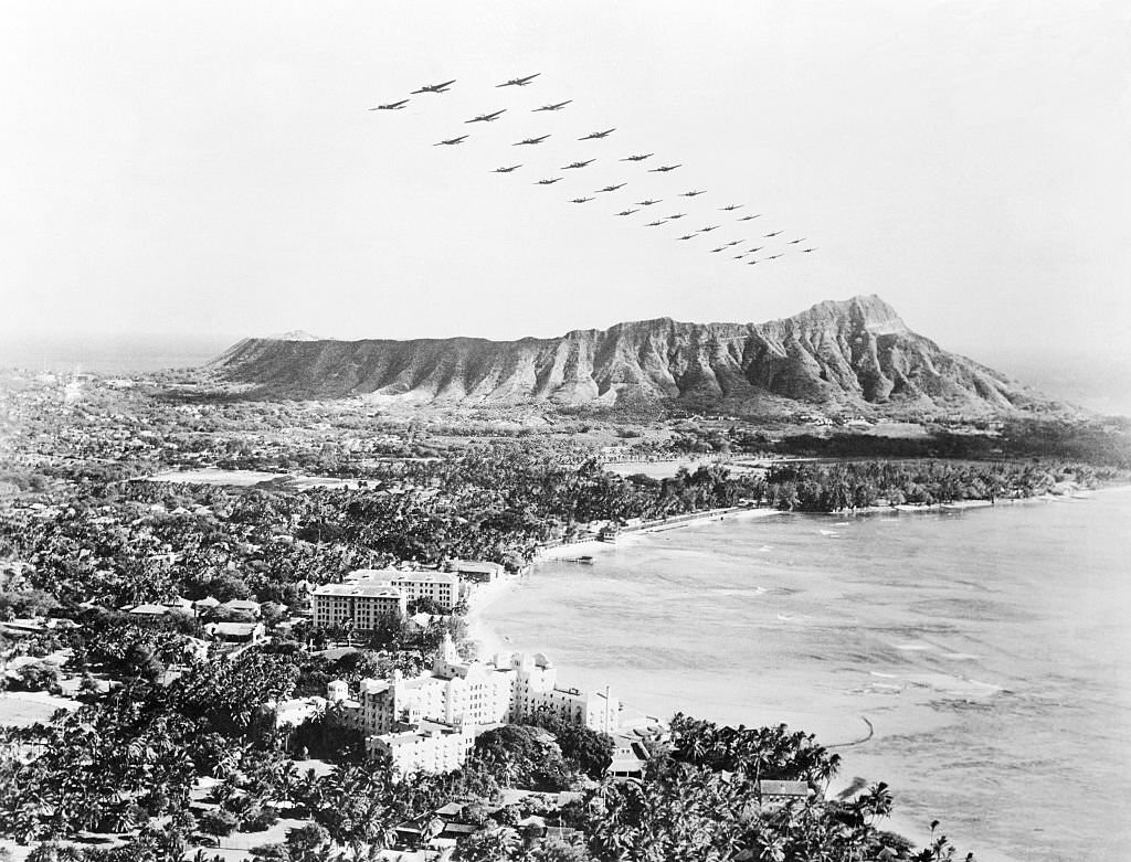 #133 The White House announced that Japanese planes attacked Hawaii. Soon after as shown here, U. S. medium bombers fly over diamond Head and beautiful Wakiki Beach at Honolulu.