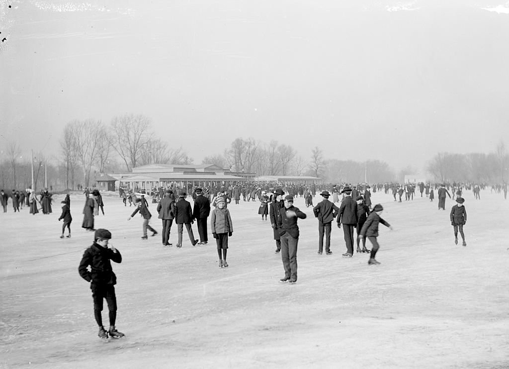 #158 Large crowd of people ice skating on the frozen lagoon at Jackson Park in the Woodlawn community area of Chicago, Illinois, 1903.
