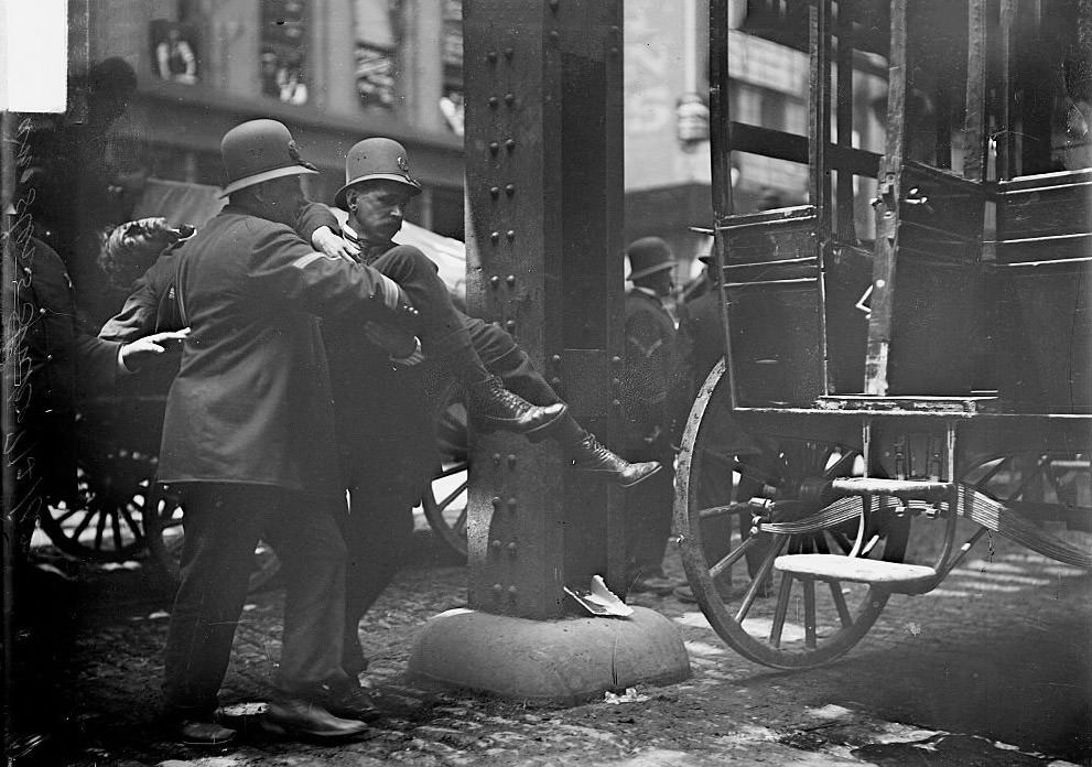 #164 Wounded man being carried to an ambulance by two policemen during the Teamsters Strike, Chicago, Illinois, June 4, 1902.